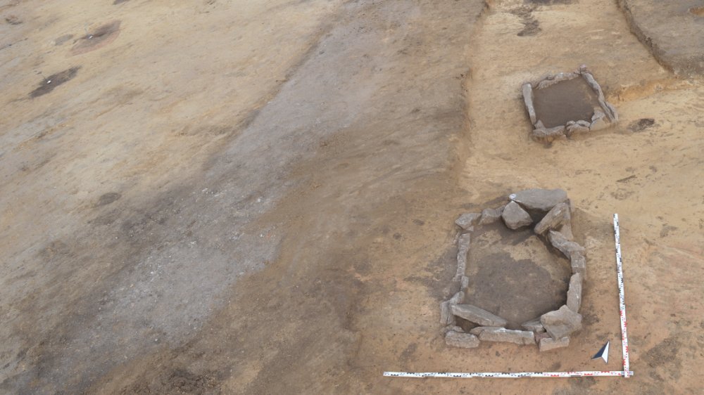 Abbildung 1: Aufgereiht von Süd nach Nord liegen drei Steinkisten. Parallel dazu sind westlich weitere Grabgrubenverfärbungen zu erkennen. © Landesamt für Denkmalpflege und Archäologie Sachsen-Anhalt, Thomas Kubenz.