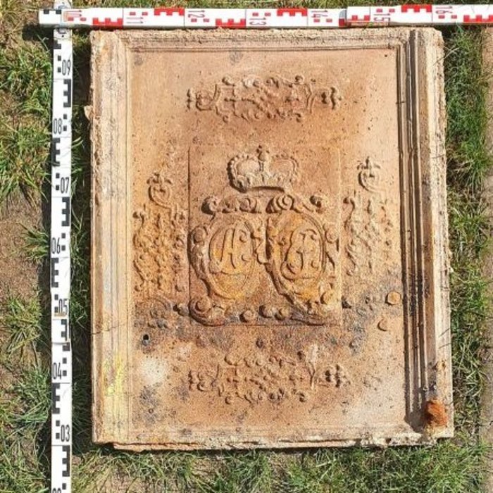 Massive gusseiserne Kaminplatte mit den umrankten und bekrönten Initialen CA (links) und JE (rechts): Christian August, Fürst von Anhalt-Zerbst (1690 bis 1747), und Johanna Elisabeth von Holstein-Gottorf (1712 bis 1760).