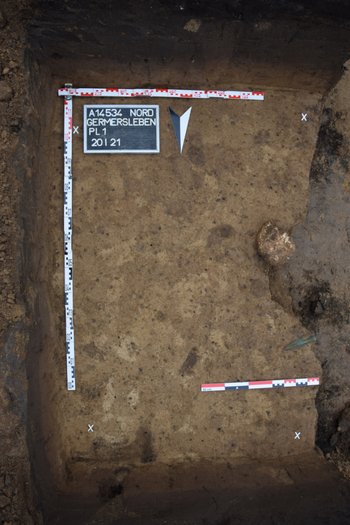 Abbildung 1: Dokumentation des Planums mit Schädelrest und Lanzenspitze. Die Lage deutet darauf hin, dass der Leichnam in Ostnordost-Südwestsüd-Orientierung bestattet wurde. © Landesamt für Denkmalpflege und Archäologie Sachsen-Anhalt, Olaf Schröder. 