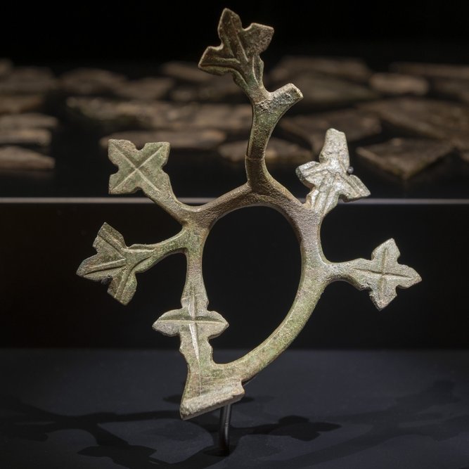 Ausstellungsimpression: das Ziergitterfragment aus Kaltenborn in der Ausstellungsvitrine, im Hintergrund zerbrochene Glasscherben. © Landesamt für Denkmalpflege und Archäologie Sachsen-Anhalt, Michel Klehm.