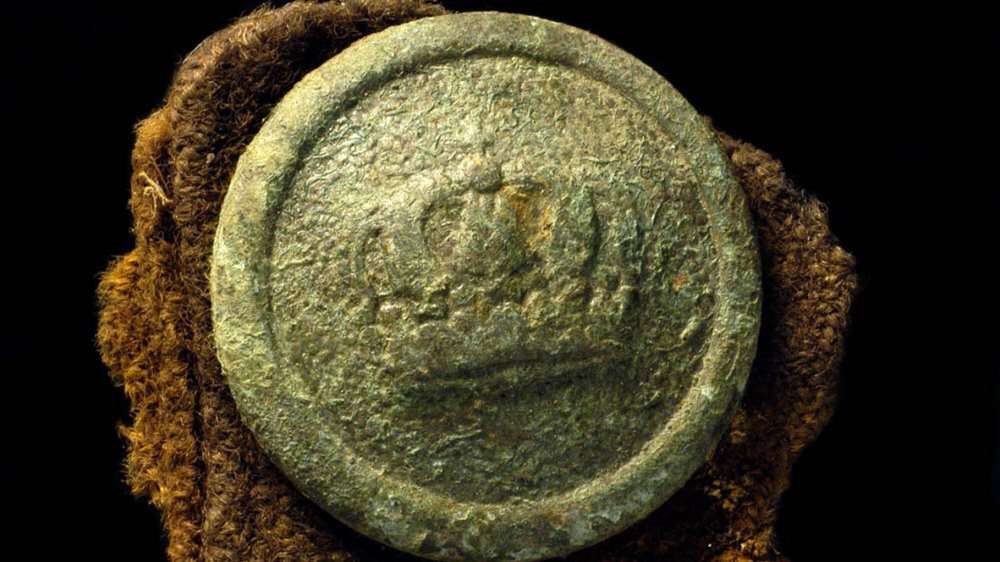 Abbildung 20: Der Knopf mit Krone gehörte vermutlich zu einer deutschen Uniform, von der sich noch Textilreste erhalten haben. © Landesamt für Denkmalpflege und Archäologie Sachsen-Anhalt, Kathrin Ulrich.