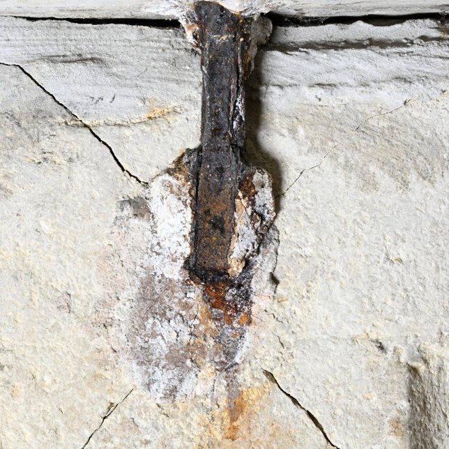 Eine der Eisenklammern unter der Deckplatte des Steinsarkophags. Deutlich erkennbar sind die vom korrodierenden Eisen ausgehenden Risse in der Seitenwand. © Landesamt für Denkmalpflege und Archäologie Sachsen-Anhalt, Denis Dittrich.