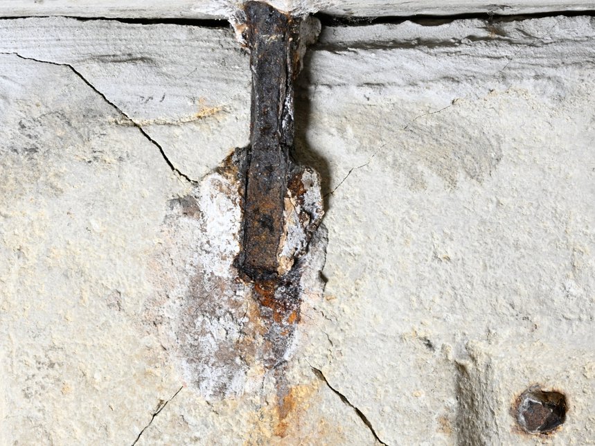 Eine der Eisenklammern unter der Deckplatte des Steinsarkophags. Deutlich erkennbar sind die vom korrodierenden Eisen ausgehenden Risse in der Seitenwand. © Landesamt für Denkmalpflege und Archäologie Sachsen-Anhalt, Denis Dittrich.