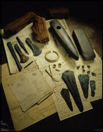Das Inventar des Fürstengrabes von Leubingen, Landkreis Sömmerda (Thüringen), besteht aus einer Überausstattung an Waffen (zwei Beile, drei Dolche und ein Stabdolch), Schmiedewerkzeugen (drei Meißel, ein Ambossstein), einem Goldornat (ein Armring, zwei Noppenringe, zwei Nadeln, ein Spiralröllchen) und einem viel älteren steinernen Schuhleistenkeil, welcher wohl der Legitimation diente. © Landesamt für Denkmalpflege und Archäologie Sachsen-Anhalt, Juraj Lipták.