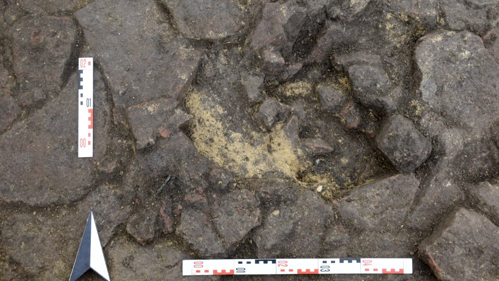 Abbildung 6: Der Boden der Gräber war mit Steinplatten ausgekleidet, am Rand eines antiken Raublochs im Befund 6005 wurde das Fragment einer Bronzenadel gefunden. © Landesamt für Denkmalpflege und Archäologie Sachsen-Anhalt, Jonathan Schulz.