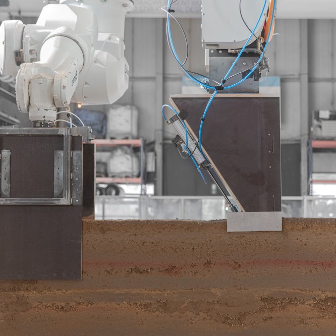 An der TU Braunschweig entwickelter Stampflehmroboter mit wandernder Schalung. Die automatisierte Verarbeitung soll nun direkt dort, wo der Erdaushub anfällt, erprobt werden. © TU Braunschweig, Joschua Gosslar.