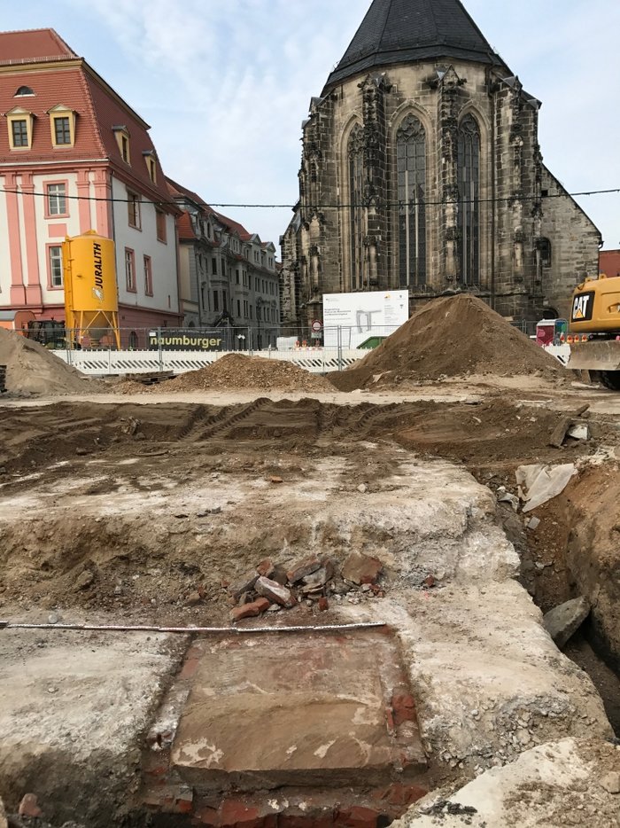 Abbildung 3: Fundament mit Grundstein während der Freilegung. Im Hintergrund ist die Marienkirche am Marktplatz zu sehen. Gegenüber von ihr, war das Denkmal am 18. August 1900 eingeweiht worden. © Landesamt für Denkmalpflege und Archäologie Sachsen-Anhalt, Madeleine Fröhlich.