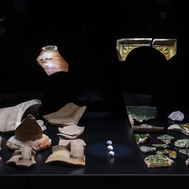 Ausstellungsimpression: Keramikscherben, Tonmurmeln und zerbrochene Ofenkacheln repräsentieren das Alltagsleben im Kloster Kaltenborn ebenso wie dessen Zerstörung. © Landesamt für Denkmalpflege und Archäologie Sachsen-Anhalt, Michel Klehm.