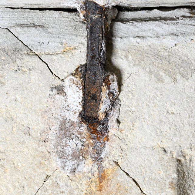 Eine der Eisenklammern unter der Deckplatte des Steinsarkophags. Deutlich erkennbar sind die vom korrodierenden Eisen ausgehenden Risse in der Seitenwand. © Landesamt für Denkmalpflege und Archäologie Sachsen-Anhalt, Denis Dittrich.